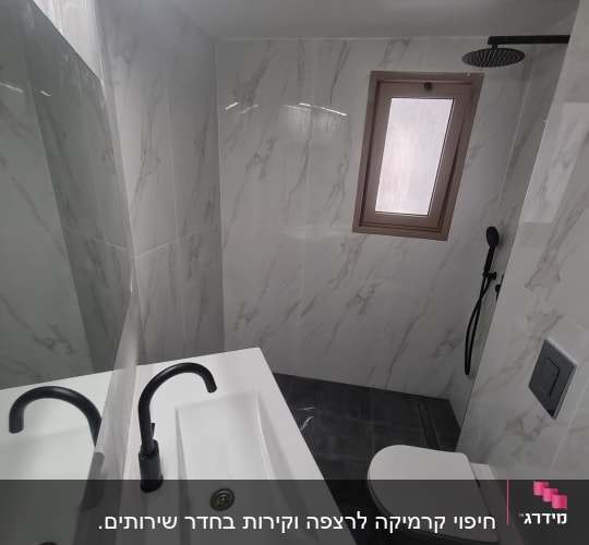 חדר אמבטיה משופץ עם כיור וברז שחור